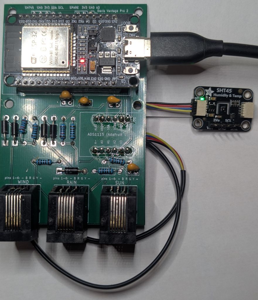 Assembled carrier board v0.1 with the ESP32 DevKit plugged in, resistors, diodes and capacitors fitted, three RJ11 jacks, and the Adafruit SHT45 sensor on its cable